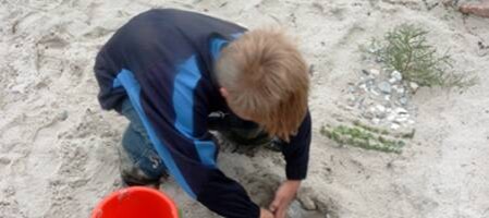 Dreng graver i sandet